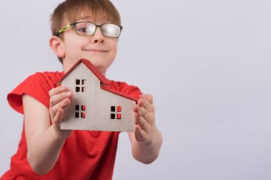 Mutlu çocuk model evi gösteriyor. Gayrimenkul, aile evi, koruyucu aile.