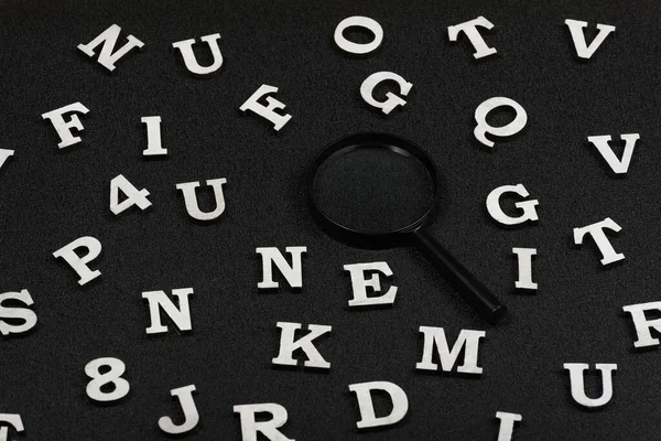 Weiße Buchstaben Und Zahlen Und Lupe Auf Schwarzem Hintergrund Suchkonzept — Stockfoto