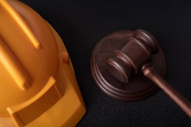 Sarı güvenlik kaskı ve Yargıç Gavel. İnşaat hukuku. Kapat..