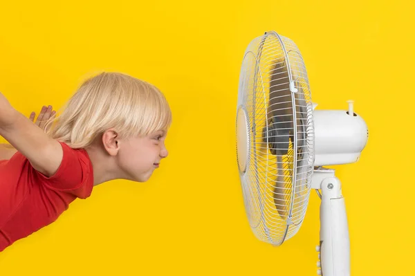 Blonďatý Chlapec Ventilátorem Relaxační Žlutém Pozadí Letní Teplo — Stock fotografie