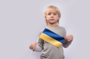 Ciddi bir genç çocuk Ukrayna bayrağını elinde tutuyor. Ukrayna 'da Vatanseverlik.