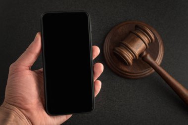 Hakim arkaplanda elinde akıllı bir telefon var. Siyah boş ekran. Uzayı kopyala Şablon. Model.