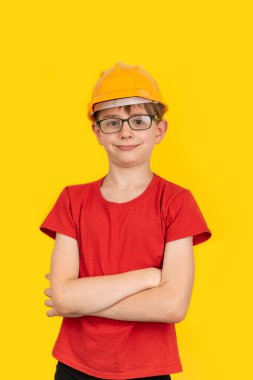 Sarı miğferli ve sarı arka planda gözlüklü bir genç. Meslek seçimi. Dikey çerçeve.