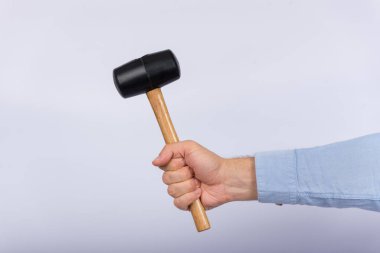 Beyaz arka planda çekiç tutan bir erkek. Yan görünüm.