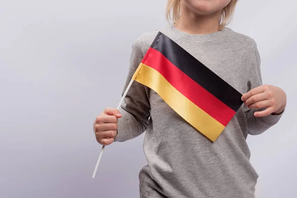 Child holds a Germany flag. Close up. School Education in Germany. Study of the German language.