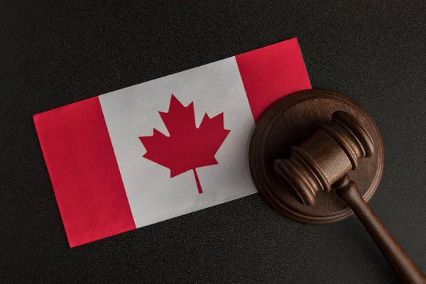 Judge Gavel and flag of Canada. Violation of human rights. Law and justice.