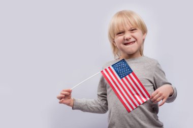 Amerikan bayrağı tutan komik çocuk. İngilizce öğrenimi ve ABD konseptinde eğitim.