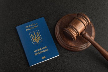 Yargıç tokmak ve Ukrayna vatandaşının pasaportu. Siyah arka plan. Vatandaşlık al