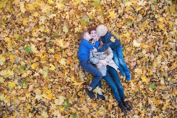 Matka Dvě Děti Leží Hromadě Listí Synové Líbají Mámu Horní — Stock fotografie