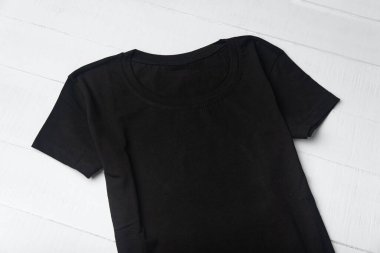 Beyaz arka planda desensiz siyah örülmüş tişört. Modelleme. Kapat.