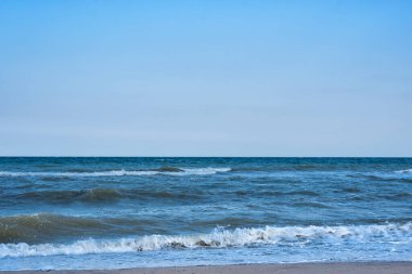 Mavi gökyüzüne karşı deniz. Dalgalar ve beyaz köpük. Denizde tatil..