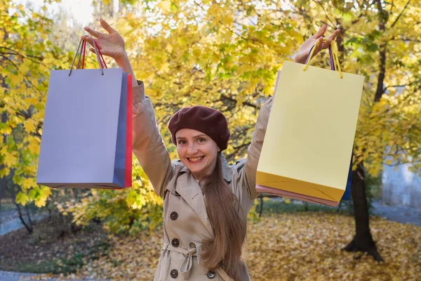 秋の公園の背景に買い物袋を持つ幸せな大人の女性 秋のセール — ストック写真
