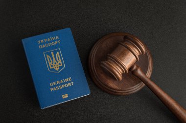 Ukrayna pasaportu ve gri siyah arka planda yargıç tokmağı. Yasal göçmenlik. Vatandaşlık al