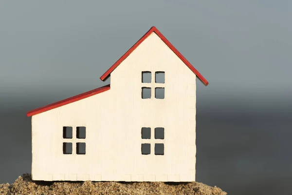 Model house on sea background. Buying home on the coast. Mortgage loan on house