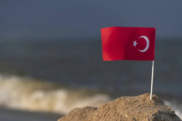 National flag of Turkey on sea background. Sea holiday in Turkey. Red flag moon and star