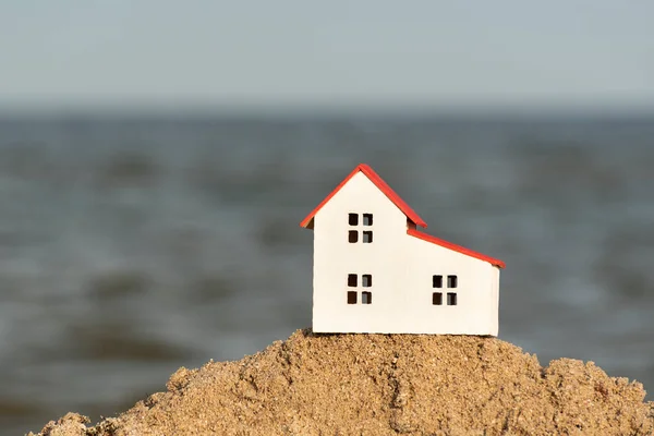 Renting house sea views. Model house on sea background. Property on the beach
