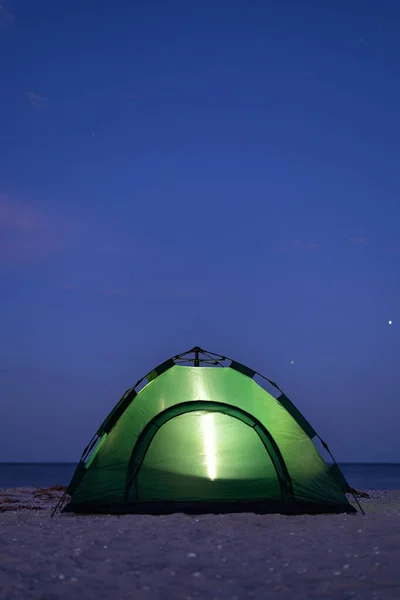 绿色的帐篷在夜间闪闪发光 在海边露营 垂直框架 — 图库照片