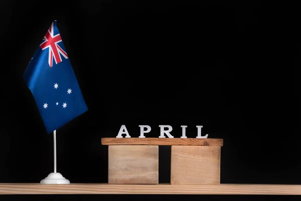 Wooden calendar of April with Australian flag on black background. Holidays of Australia in April.