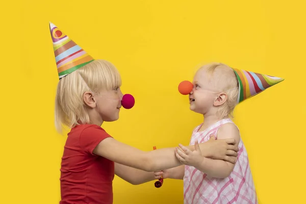 Twee Kinderen Met Feestelijke Hoeden Rode Clownneuzen Hebben Plezier Kinderfeestje — Stockfoto