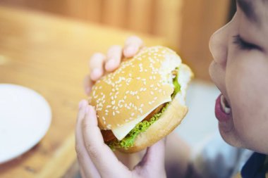 Çocuk hamburger kahvaltı bulanıklık ahşap masa arka plan - lezzetli lokanta kahvaltı kavramı ile