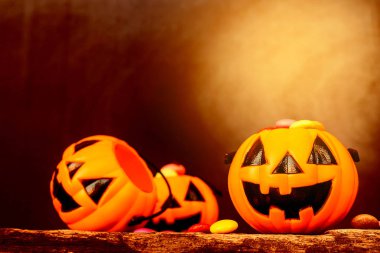 Cadılar Bayramı Balkabağı yüz kova şeker kahverengi degrade arka plan üzerinde eski ahşap doku ile