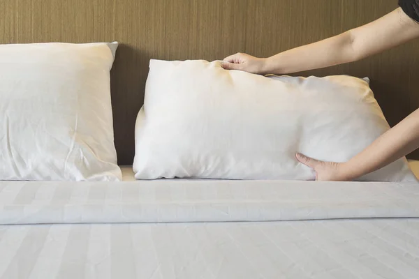 Lady hands set up white bed sheet in hotel room