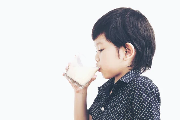 アジアの少年の白い背景の上の牛乳のガラスを飲むのビンテージ写真 — ストック写真