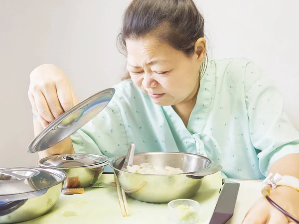 A lady patient is boring food in a hospital