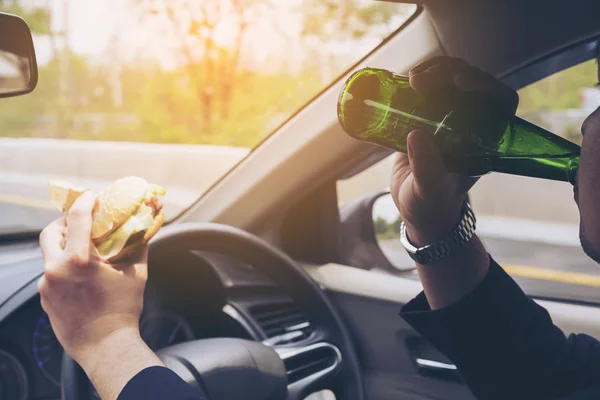 Mężczyzna Jadący Samochód Podczas Jedzenia Hamburgera Pić Piwo — Zdjęcie stockowe