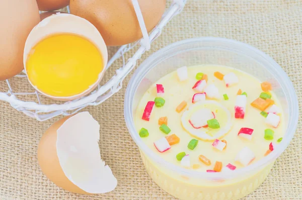 Thai steamed eggs with fresh beaten egg on sack background