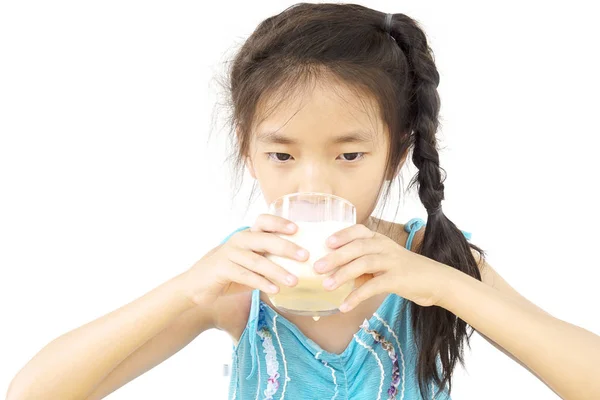 アジアの女の子は白い背景の上の牛乳のガラスを飲む — ストック写真