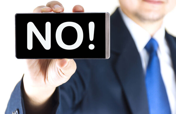 NO!, word on mobile phone screen in blurred young businessman hand over white background, business concept