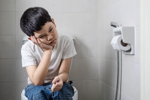 Asian boy sitting on toilet bowl - health problem concept — Stock Image Asian Boy Sitting Toilet Bowl Health Problem Concept Stock Photo