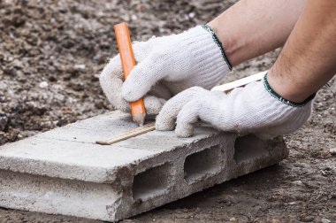 İnşaat işçisi çalışıyor ile çimento blok ölçüm hazırlamak için kesme.