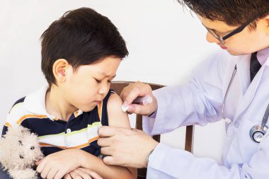 Beyaz arka plan üzerinde erkek doktor tarafından tedavi hasta Asyalı çocuk