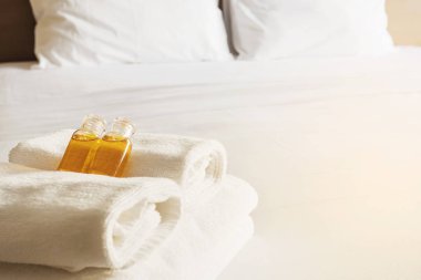 Otel havlu ile beyaz yatakta ayarla şişe şampuan ve sabun