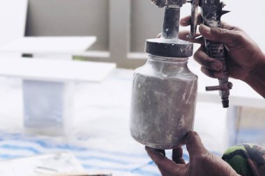 Mobilya - işçi boyama mobilya yerinde kavramı, yeni ev yükleme işleminde renk sprey boya makinesi ile çalışan adam