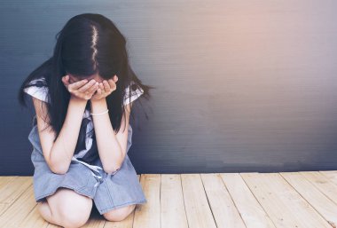 Ahşap katta oturan üzgün Asyalı kız