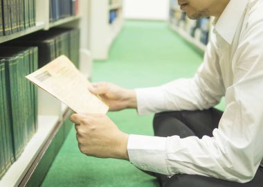 Bir adam Gazeteler kitaplık kütüphane yakın geçmişte okuyor