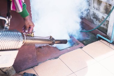 Adam yayılan sivrisinek korumak için termal sis makinesi kullanıyor