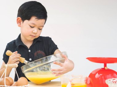 Bir çocuk pasta yapıyor. Fotoğraf gözlerine odaklanmıştır.