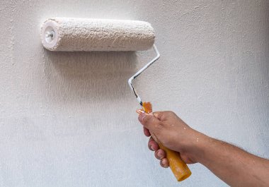 Çalışırken boya fırçası, duvar resmi tutan el