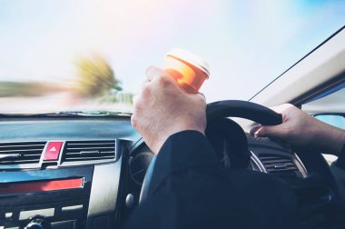 Bir fincan sıcak kahve - uykulu sürüş araba ya da uykuya kavramı tutarken adam sürücü araba