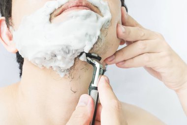 Adam tıraş makinesi kullanıyor