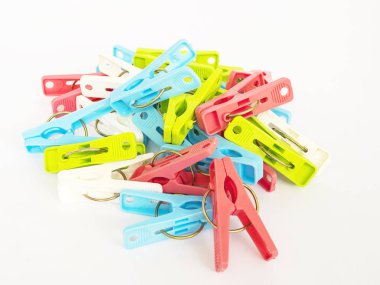 Beyaz arka plan üzerinde renkli plastik clothespins dönüştürün