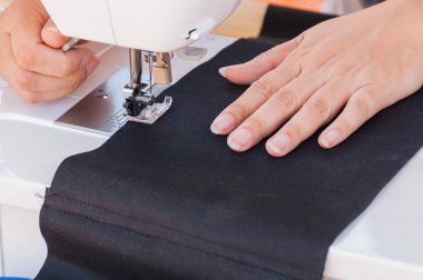 Dikiş makinesi kullanarak patchwork yapıyor eller,