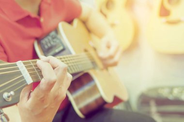 Adamın Vintage Fotoğraf gitar gitar arka plan asılı ile oynuyor