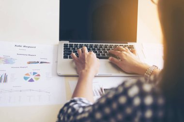 İş kadını dizüstü bilgisayar ve grafik veya grafik ile bir tablo üzerinde çalışıyor