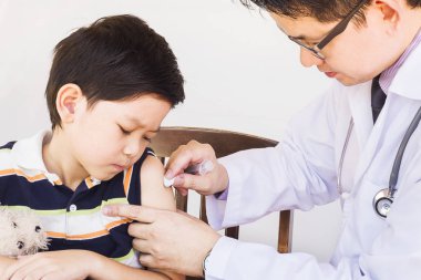 Beyaz arka plan üzerinde erkek doktor tarafından tedavi hasta Asyalı çocuk