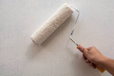 Çalışırken boya fırçası, duvar resmi tutan el
